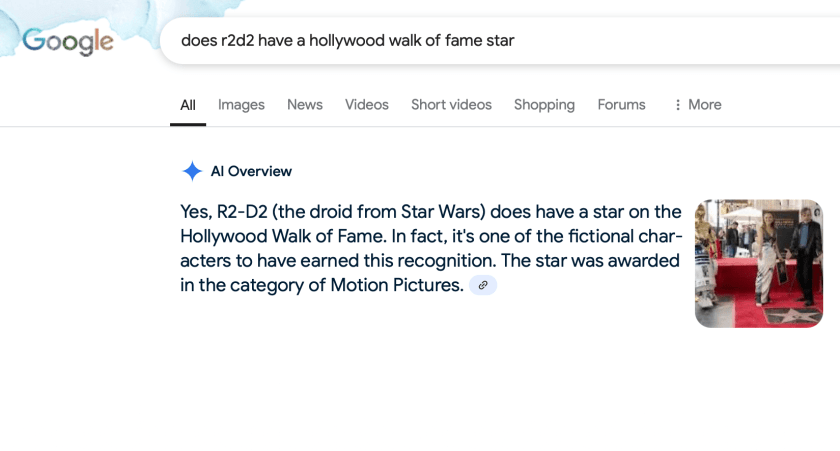 screenshot of a Google search result with an AI Overview that says that "Yes, R2-D2 (the droid from Star Wars) does have a star on the Hollywood Walk of Fame. In fact, it's one o the fictional characters to have earned this recognition. The star was awarded in the category of Motion Pictures." There is a thumbnail image of a star ceremony next to it.